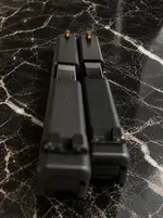 Twin Handgun Slides on Black Marble.webp